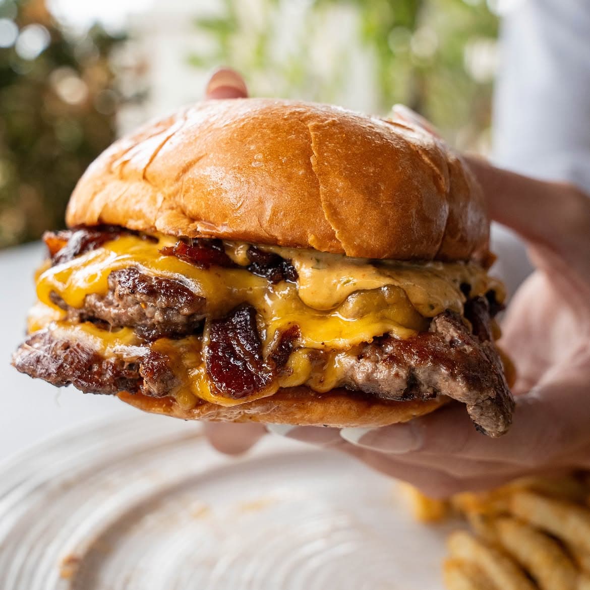 Close-up of High Marea’s double smash burger with melted cheddar and bacon jam on a brioche bun